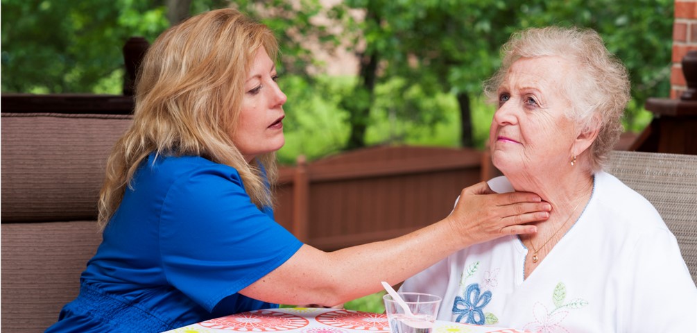 a speech language pathologist works with an older adult woman